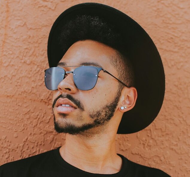 man leaning on brown wall